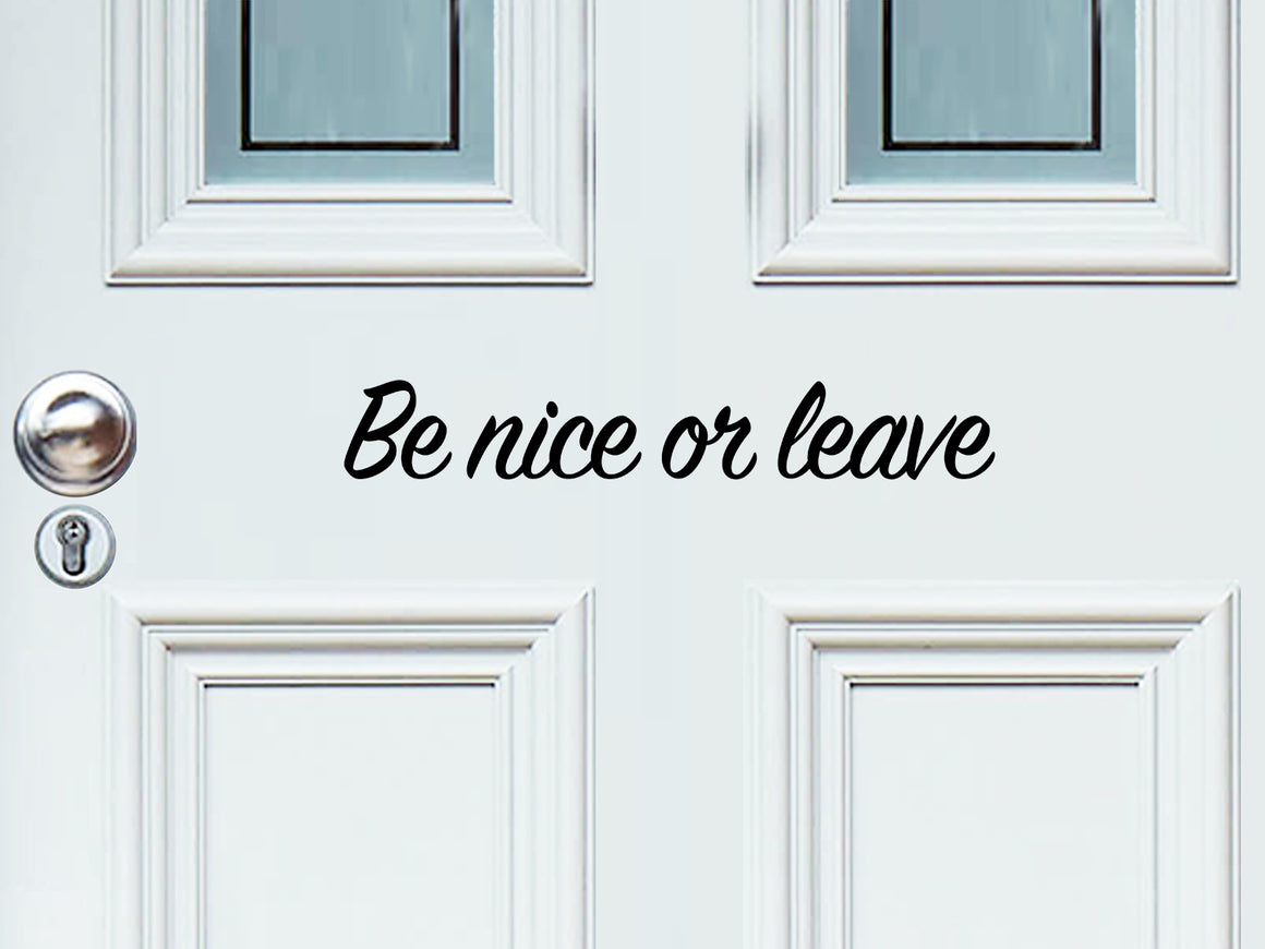 Front door decal that says, ‘Be Nice Or Leave’ in a script font on a front porch door.