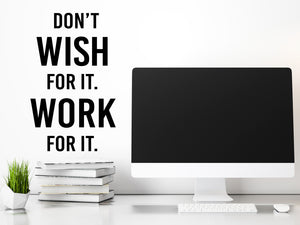 Decorative wall decal that says ‘Don't Wish For It Work For It’ on an office wall.