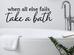 Wall decals for bathroom that say ‘When All Else Fails Take A Bath’ in a cursive font on a bathroom wall.