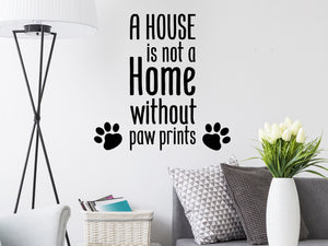 Living room wall decals that say ‘A house is not a home without paw prints’ on a living room wall. 