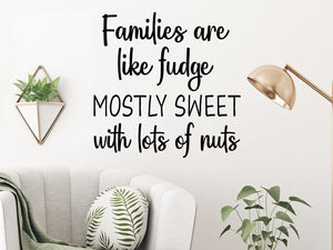 Living room wall decals that say ‘Families are like fudge mostly sweet with lots of nuts’ in a bold font on a living room wall. 