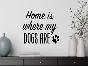 Living room wall decals that say ‘Home Is Where My Dogs Are’ in a cursive font on a living room wall. 