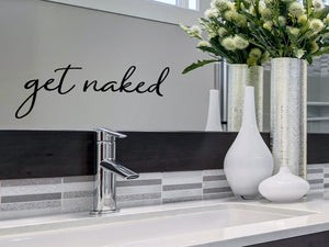 Wall decals for bathroom that say ‘get naked’ in a cursive font on a bathroom wall.
