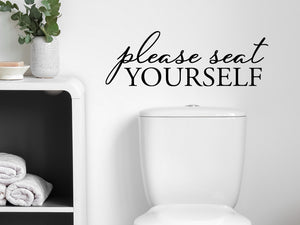 Wall decals for bathroom that say ‘Please Seat Yourself’ in a script font on a bathroom wall.