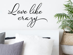 Wall decal for bedroom that says ‘love like crazy’ on a bedroom wall.