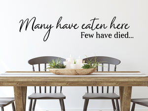 Wall decals for kitchen that say ‘Many Have Eaten Here Few Have Died’ in a cursive font on a kitchen wall.