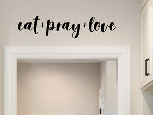 Wall decals for kitchen that say ‘eat + pray + love’ on a kitchen wall.