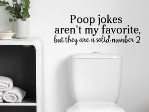 Wall decals for bathroom that say ‘Poop Jokes Aren't My Favorite’ in a cursive font on a bathroom wall.