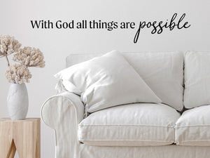 Living room wall decals that say ‘With God All Things Are Possible’ in a script font on a living room wall. 