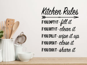 Wall decals for kitchen that say ‘Kitchen Rules’ in a cursive font on a kitchen wall.