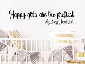 Wall decal for kids that says ‘Happy girls are the prettiest, Audrey Hepburn’ on a kid’s room wall. 