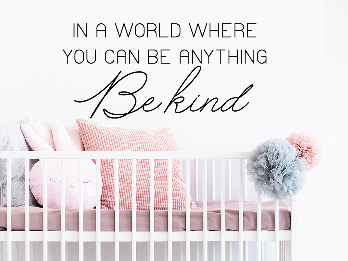Wall decal for kids that says ‘In a world where you be anything be kind’ in a script font on a kid’s room wall.