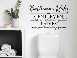 Wall decals for bathroom that say ‘Bathroom Rules (Gentleman & Ladies)’ in a script font on a bathroom wall.