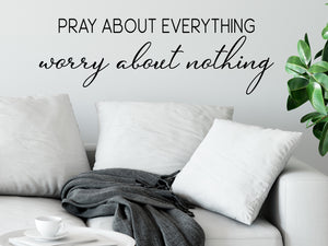 Living room wall decals that say ‘pray about everything worry about nothing’ on a living room wall. 