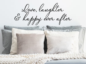 Wall decal for bedroom that says ‘love, laughter & happy ever after’ on a bedroom wall.