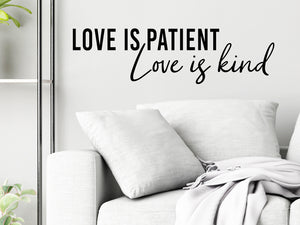 Living room wall decals that say ‘Love Is Patient Love Is Kind’ in a bold font on a living room wall. 