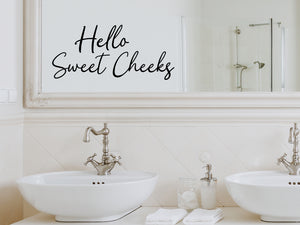 Wall decals for bathroom that say ‘Hello Sweet Cheeks’ in a cursive font on a bathroom wall.