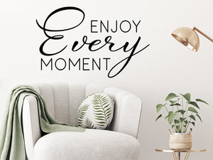 Living room wall decals that say ‘Enjoy every moment’ on a living room wall. 