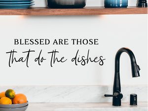 Wall decals for kitchen that say ‘Blessed Are Those Who Do The Dishes’ in a print font on a kitchen wall.