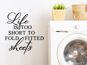 Laundry room wall decal that says ‘Life Is Too Short To Fold Fitted Sheets’ on a laundry room wall