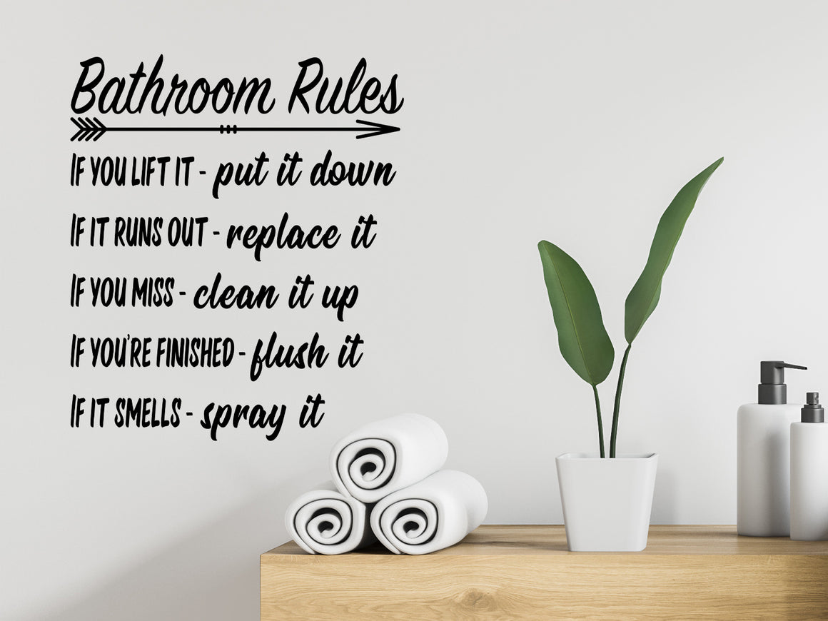 Wall decals for bathroom that say ‘Bathroom Rules If You Lift It Put It Down’ in a bold font on a bathroom wall.