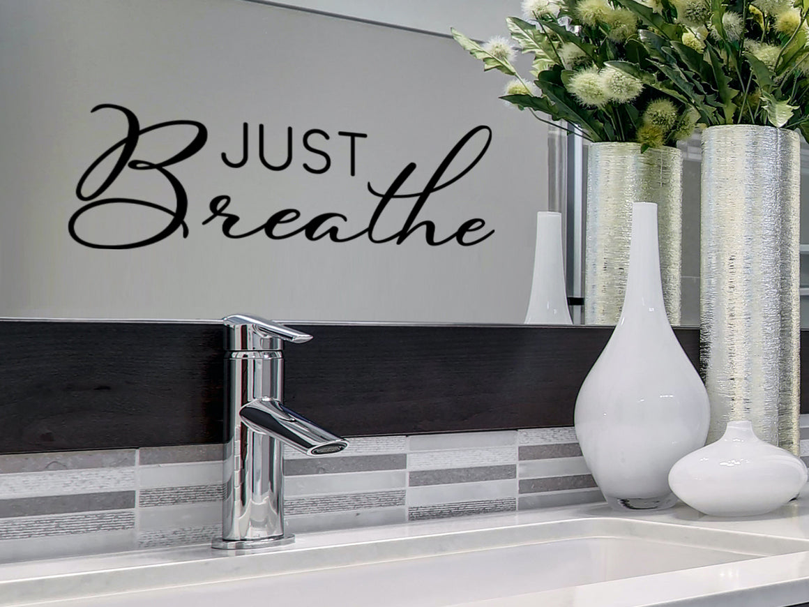 Wall decals for bathroom that say ‘Just Breathe’ in a script font on a bathroom mirror.