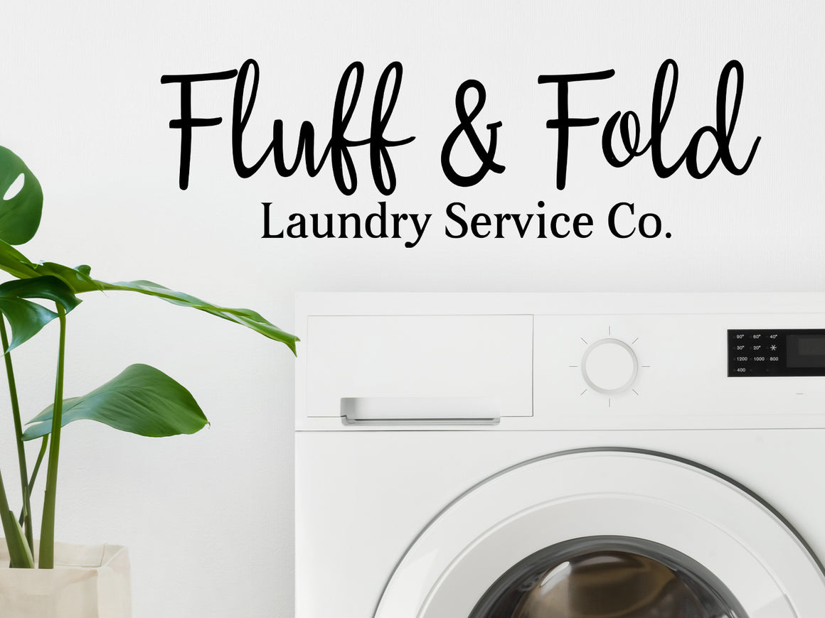 Decorative wall decal that says ‘Fluff & Fold Laundry Service Co.’ on a laundry room wall.