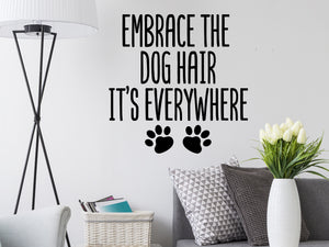Living room wall decals that say ‘Embrace the dog hair it's everywhere’ on a living room wall. 