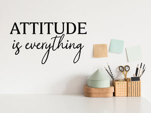 Wall decal for the office that says ‘Attitude Is Everything’ in a script font on an office wall.