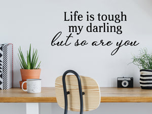 Wall decal for the office that says ‘Life Is Tough My Darling But So Are You’ in a bold font on an office wall.