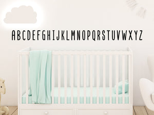 Decorative wall decal that has all the letters of the alphabet in all uppercase letters on a kid’s room wall. 