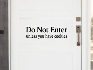 Front door decal that says, ‘Do Not Enter Unless You Have Cookies’ on a front porch door. 