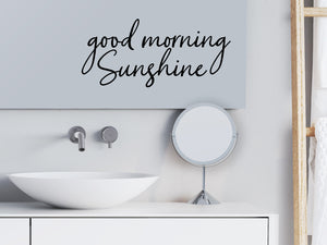 Wall decals for bathroom that say ‘Good Morning Sunshine’ in a cursive font on a bathroom wall.