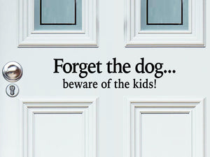 Front door decal that says, ‘Forget the dog...beware of the kids!’ in a print font on a front porch door. 