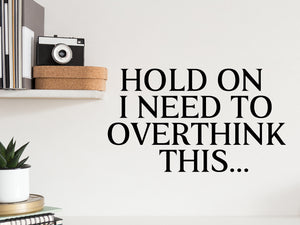 Wall decal for the office that says ‘Hold On I Need To Overthink This’ in a print font on an office wall.