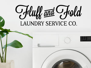 Laundry room wall decal that says ‘Fluff And Fold Laundry Service Co.’ on a laundry room wall.