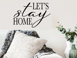 Living room wall decals that say ‘let's stay home’ on a living room wall. 