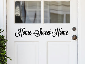 Front door decal that says, ‘Home Sweet Home’ in a cursive font  on a front porch door. 