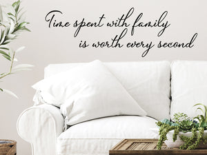 Living room wall decals that say ‘Time Spent With Family Is Worth Every Second’ in a cursive font on a living room wall. 