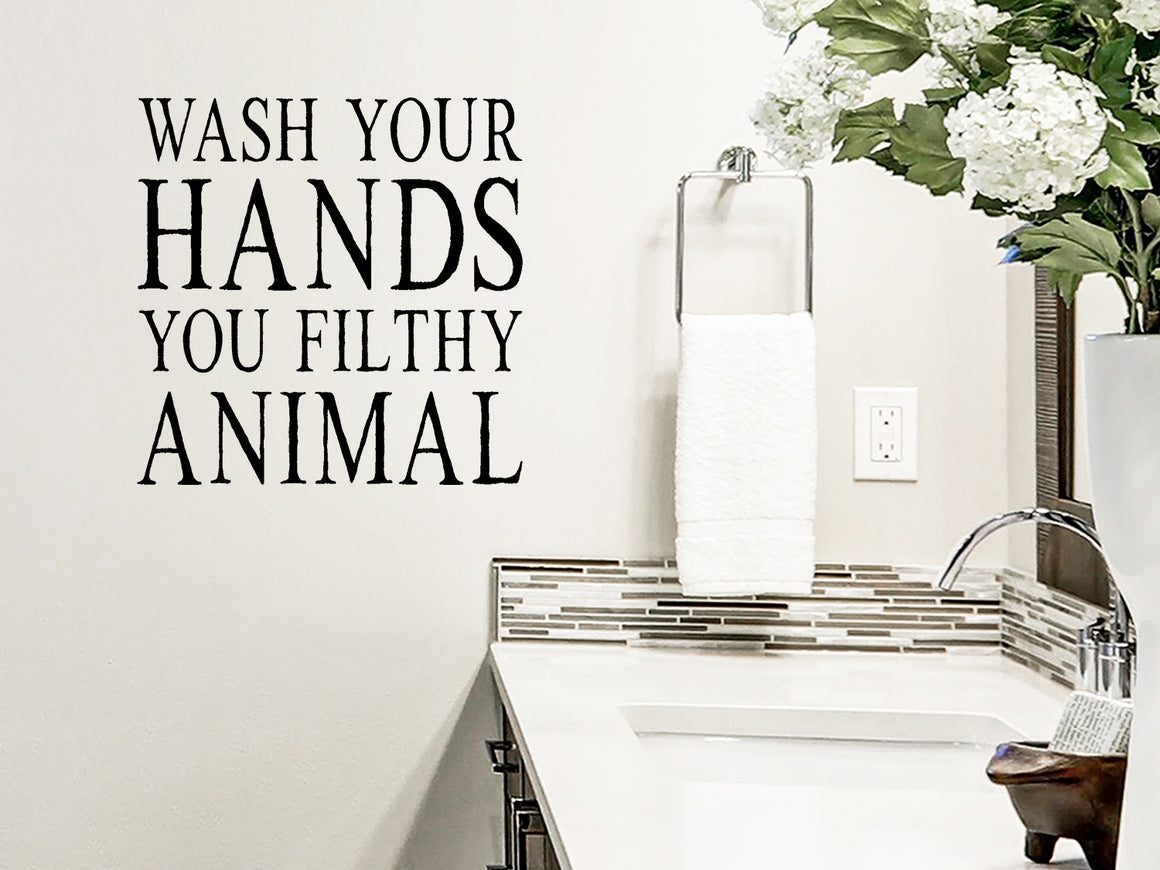 Wall decals for bathroom that say ‘wash your hands you filthy animal’ on a bathroom wall.