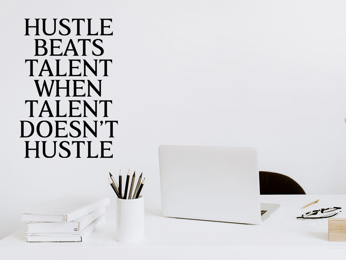Wall decal for the office that says ‘Hustle Beats Talent When Talent Doesn’t Hustle’ in a print font on an office wall.