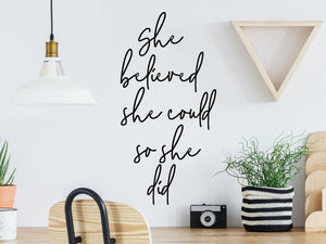 Decorative wall decal that says ‘She Believed She Could So She Did’ on an office wall.