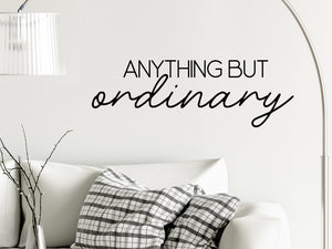 Living room wall decals that say ‘Anything but ordinary’ on a living room wall. 