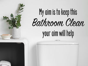 Wall decals for the bathroom that say ‘My Aim Is To Keep This Bathroom Clean Your Aim Will Help’ on a bathroom wall.
