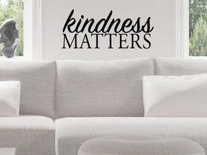 Living room wall decals that say ‘Kindness Matters’ in a bold font on a living room wall. 