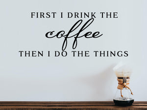 Wall decals for kitchen that say ‘First I Drink The Coffee Then I Do The Things’ in a print font on a kitchen wall.