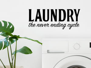 Laundry room wall decal that says ‘Laundry The Never Ending Cycle’ in a bold font on a laundry room wall.
