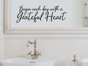 Wall decals for bathroom that say ‘Begin Each Day With A Grateful Heart’ in a cursive font on a bathroom wall.