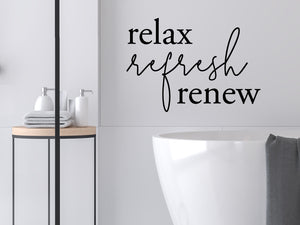 Wall decals for bathroom that say ‘Relax Refresh Renew’ in a script font on a bathroom wall.