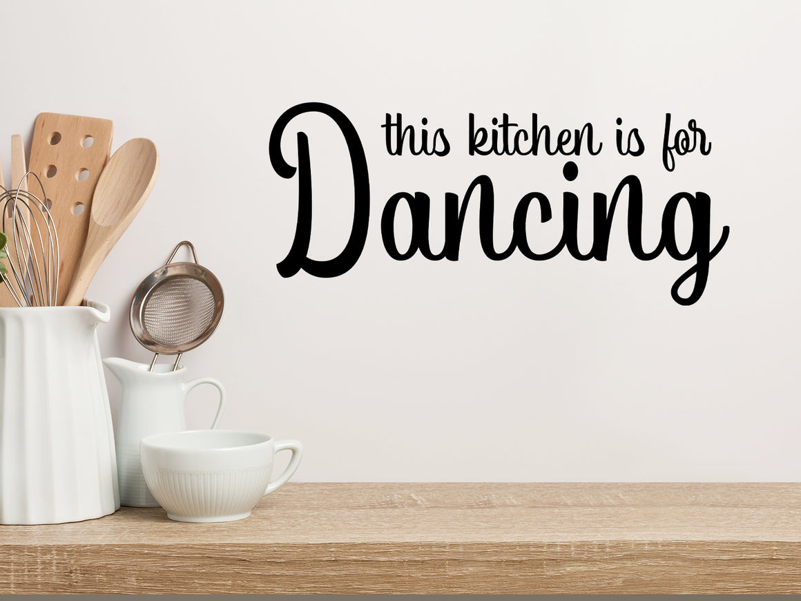 Wall decals for kitchen that say ‘This Kitchen Is For Dancing’ in a script font on a kitchen wall.